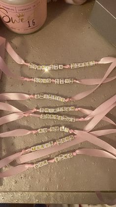 some pink ribbons are on a table next to a bottle