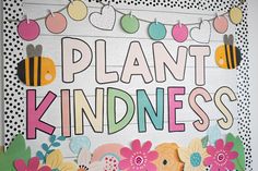 a sign that says plant kindness with flowers and bees hanging from the side of it