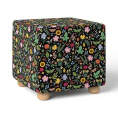 a black floral box with wooden legs on a white background, it's all covered in colorful flowers and leaves