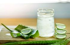 a wooden cutting board topped with cucumber slices and a jar