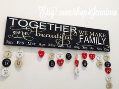 a sign that says together we make family with hearts hanging from it's sides