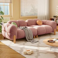 a living room filled with furniture and a pink couch in front of a large window