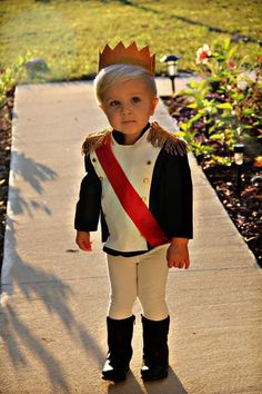 a little boy dressed up as a baby in english, standing on a sidewalk with the caption bebe en espanol