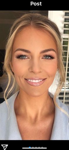 a woman with blonde hair and blue eyes smiles at the camera while she is taking a selfie