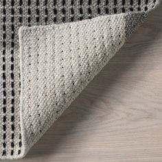 a close up view of the corner of a rug with black and white squares on it