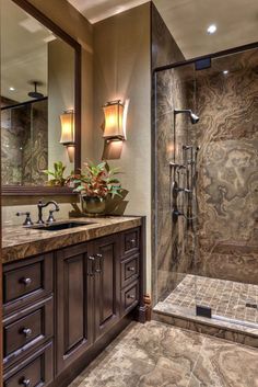 a bathroom with marble counter tops and wooden cabinets, along with a walk in shower