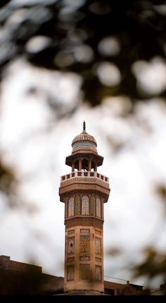 a tall tower with a clock on it's side and sky in the background