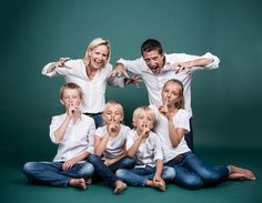 a group of people sitting on top of each other posing for a photo with their hands in the air