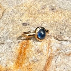 This is a very simple yet stunning 14k gold ring, featuring a pale blue sapphire cabochon.  This stone is pale to medium, soft but deep blue. It has great luster. A truly beautiful 3,39ct natural sapphire cabochon. It is bezel set, and open back. The shank is a simple half round gold strip. This is a beautiful and solid ring. This ring is size 8 1/2 Thank you for looking! 14k Gold Sapphire Ring Oval Cabochon, Classic Oval Blue Moonstone Ring, Blue Oval Moonstone Ring In 14k Gold, 14k Gold Oval Cabochon Moonstone Ring, Oval Solitaire Moonstone Ring In 14k Gold, Blue Sapphire Ring Oval Cabochon, Blue Oval Moonstone Ring With Polished Finish, Oval Blue Moonstone Ring With Polished Finish, Blue Round Moonstone Ring In 14k Gold