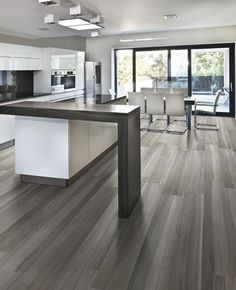 a modern kitchen with white cabinets and wood flooring