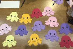 an assortment of octopus cut outs sitting on top of a wooden table