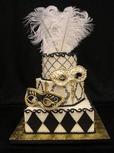 a three tiered cake decorated with masquerades and feathers on black background