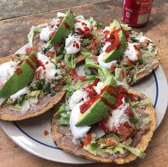 an open face pizza with lettuce and tomatoes on it sitting on a plate