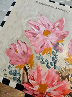 some pink flowers are sitting on a piece of paper