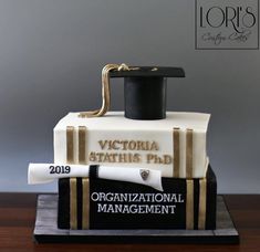 a cake made to look like a graduation cap and diploma is on top of a stack of books