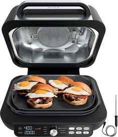 an electric sandwich maker with four burgers in it