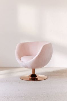 a pink chair sitting on top of a metal base in front of a white wall