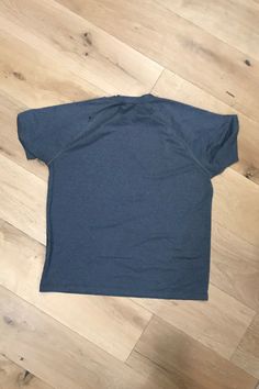 a blue shirt laying on top of a wooden floor