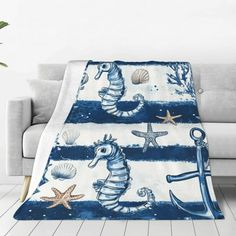 a blue and white blanket with seahorses, starfish, and anchors on it