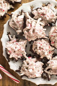 a white plate topped with cookies covered in candy canes and marshmallows