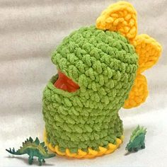 there is a crocheted stuffed animal that looks like a green monster with yellow horns