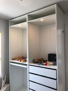 an empty room with white shelves and drawers in the middle, all lined up on top of each other