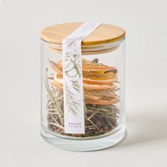 a jar filled with dried herbs on top of a white table