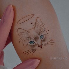 a cat with blue eyes is on the back of a woman's shoulder and arm