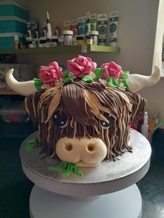 a cake decorated to look like a cow with flowers on its head