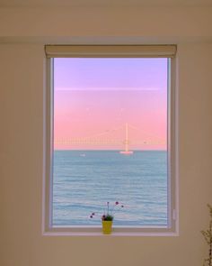 there is a window with a view of the water and bridge in the distance,