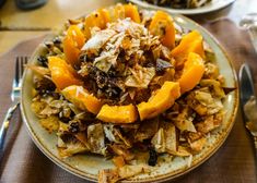 a white plate topped with lots of food on top of a table next to silverware