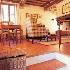 a living room filled with furniture and a fire place next to a wooden floored stair case