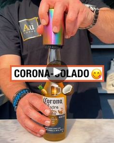 a man is making a drink with a rainbow colored bottle in front of him and the caption reads corona cola