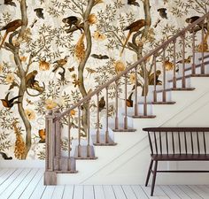 a stair case next to a tree with birds on it and a wall paper behind it