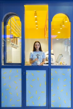 a woman standing in front of a window with yellow sprinkles on it