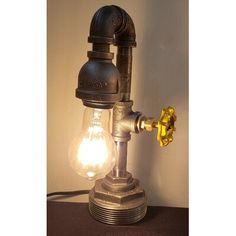 a light that is on top of a table next to a wall mounted lamp with an old fashioned faucet