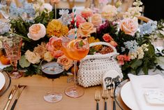 the table is set with flowers and wine glasses, silverware, and napkins