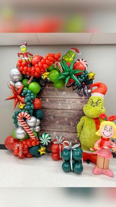 a large wooden box filled with lots of balloons and christmas decorations on top of a table