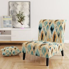 a chair and ottoman in a room with wood flooring, white walls and paintings on the wall