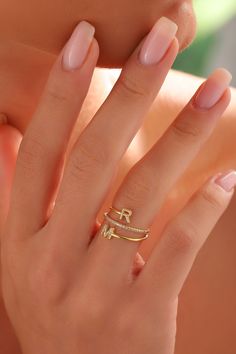 a woman's hand with two gold rings on her fingers and one ring in the middle