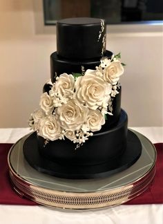 a black and white wedding cake with flowers on top