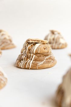 cookies with white icing and drizzled on them sitting on a table