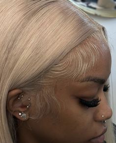 a woman with blonde hair and piercings on her ears