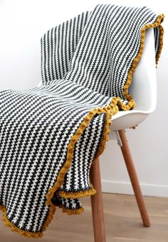 a black and white blanket sitting on top of a chair