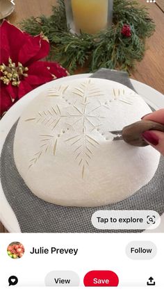 someone is cutting out a snowflake on a plate