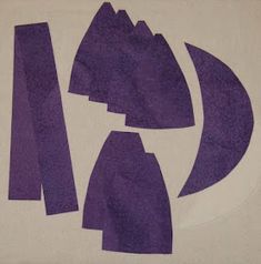 purple paper cut out into shapes on a white surface