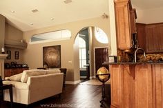 a living room filled with furniture next to a kitchen and dining room table in front of a doorway