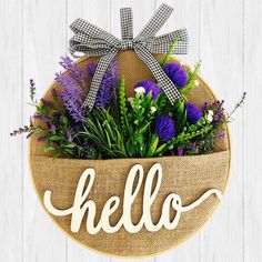 a burlock with the word hello written on it and purple flowers in front