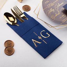 a blue napkin with gold foil on it next to some silverware and other items