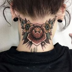 a woman's neck with a flower tattoo on it